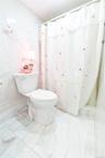 Bathroom with stone wall, marble tiled flooring, a shower with curtain, and tile walls