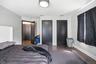 Spacious room featuring dark wood-finish flooring, light grey walls, and white baseboards