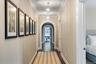 Hall featuring arched walkways, ornamental molding, and wood finished floors