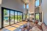 Living area with a fireplace, wood finished floors, and a high ceiling