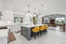 Kitchen with stainless steel range, recessed lighting, light countertops, an island with sink, and arched walkways