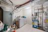 Washroom featuring water heater, washing machine and dryer, light tile patterned flooring, heating unit, and a heating unit