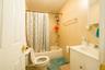 Full bathroom featuring tile walls, vanity, shower / bath combo, and toilet