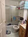 Bathroom with vanity, shower / bath combination with glass door, and light tile patterned flooring