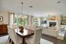 Dining room with a chandelier, ornamental molding, a glass covered fireplace, and dark wood-type flooring