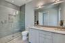 Bathroom with toilet, an enclosed shower, and vanity
