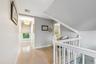 Corridor with light wood-style flooring and an upstairs landing