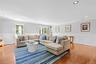 Living area with crown molding, recessed lighting, light wood finished floors, and a decorative wall