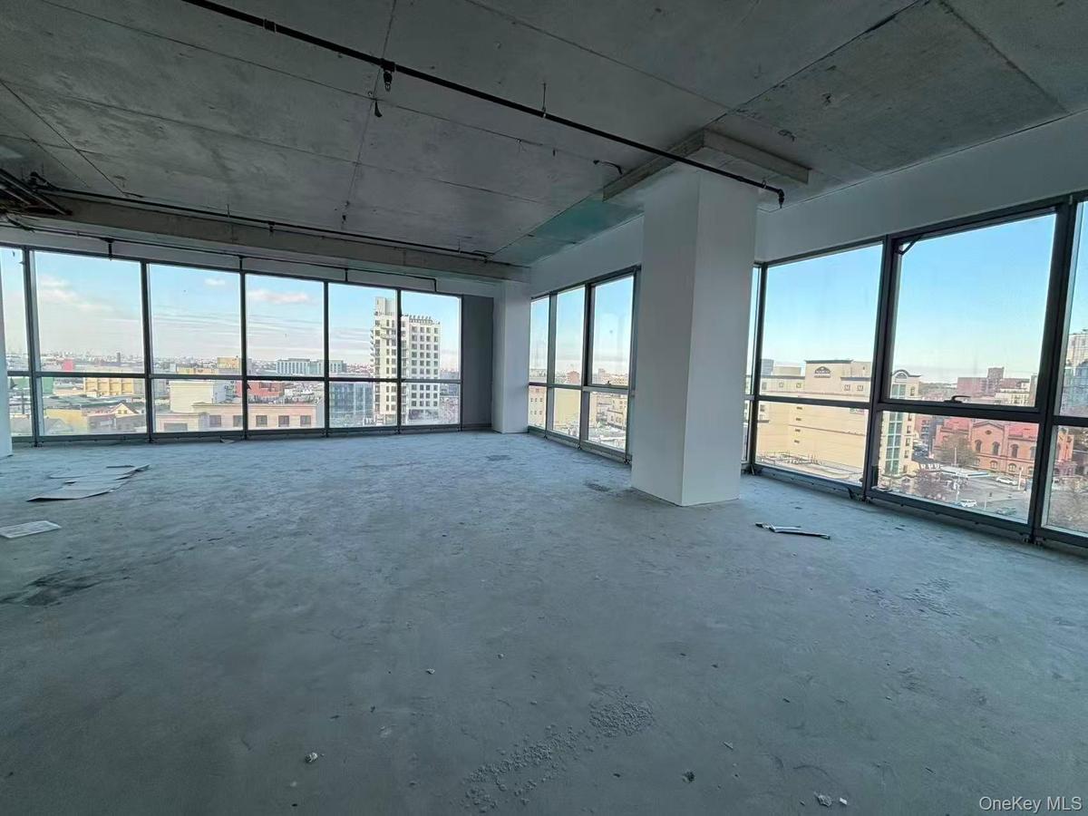 Empty room with healthy amount of natural light, a city view, and concrete floors
