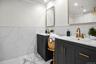 Dual vanities with quartz counters, gold fixtures, and modern mirrors create a sleek and luxurious setting.
