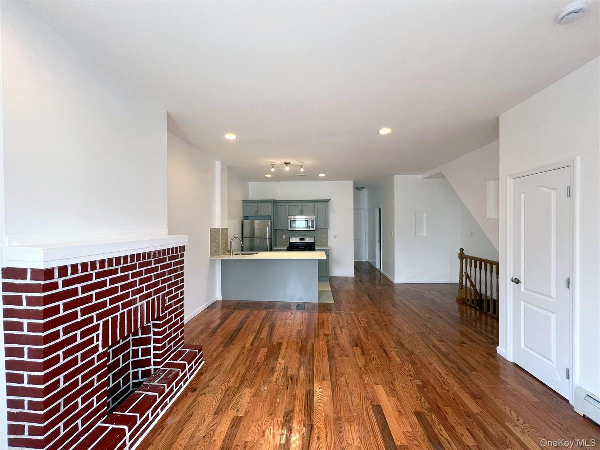 Unfurnished living room featuring dark wood-type flooring, recessed lighting, and baseboard heating