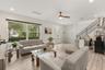 Inviting living room with abundant natural light, high ceilings, and an open layout that creates a bright and welcoming atmosphere.