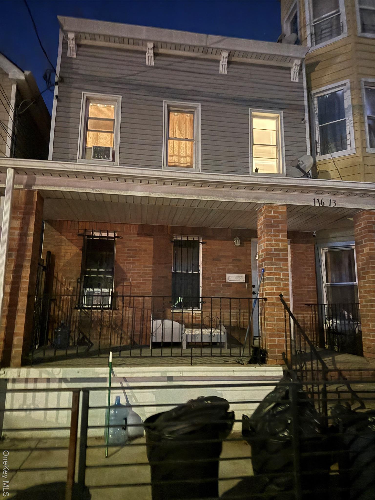 View of front facade featuring a porch and brick siding