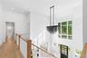 Corridor featuring recessed lighting, light wood-type flooring, a towering ceiling, ornamental molding, and a chandelier