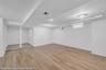 Spacious room featuring wood-finish flooring, recessed lighting, and a neutral color palette