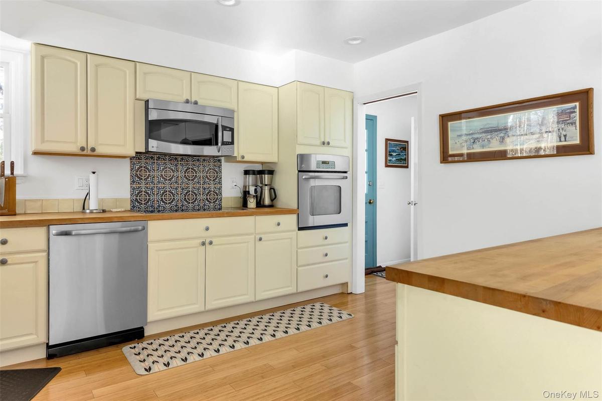 Kitchen with stainless steel appliances, butcher block countertops, and light wood-type flooring