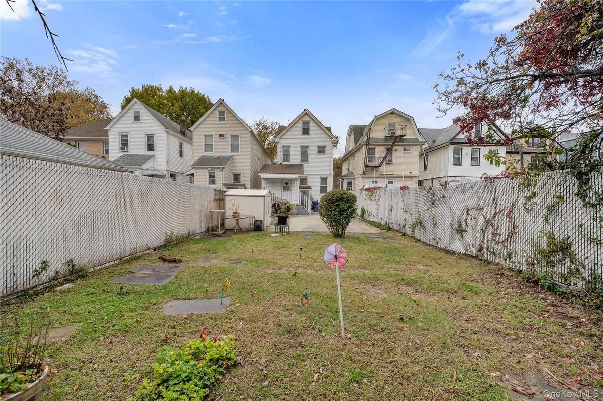 Fenced backyard featuring a residential view and an outbuilding