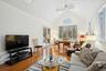 Living room featuring beamed ceiling, high vaulted ceiling, light hardwood / wood-style flooring, and ceiling fan