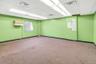 Carpeted empty room with a drop ceiling and baseboards