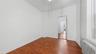 Unfurnished bedroom featuring radiator heating unit and dark wood-style floors