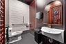 Half bathroom featuring toilet and dark tile patterned flooring
