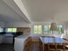 Kitchen featuring white cabinetry, gas range oven, decorative backsplash, a kitchen breakfast bar, and plenty of natural light