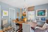 Dining area featuring light blue walls, a white decorative chandelier, a wood-finish table, and a window with blinds
