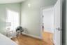 Bedroom with wood finished floors, lofted ceiling, and baseboards