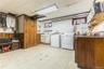 Laundry area with light floors, plenty of natural light, wooden walls, independent washer and dryer, and wainscoting
