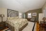 Bedroom featuring lofted ceiling, recessed lighting, wood finished floors, and baseboard heating