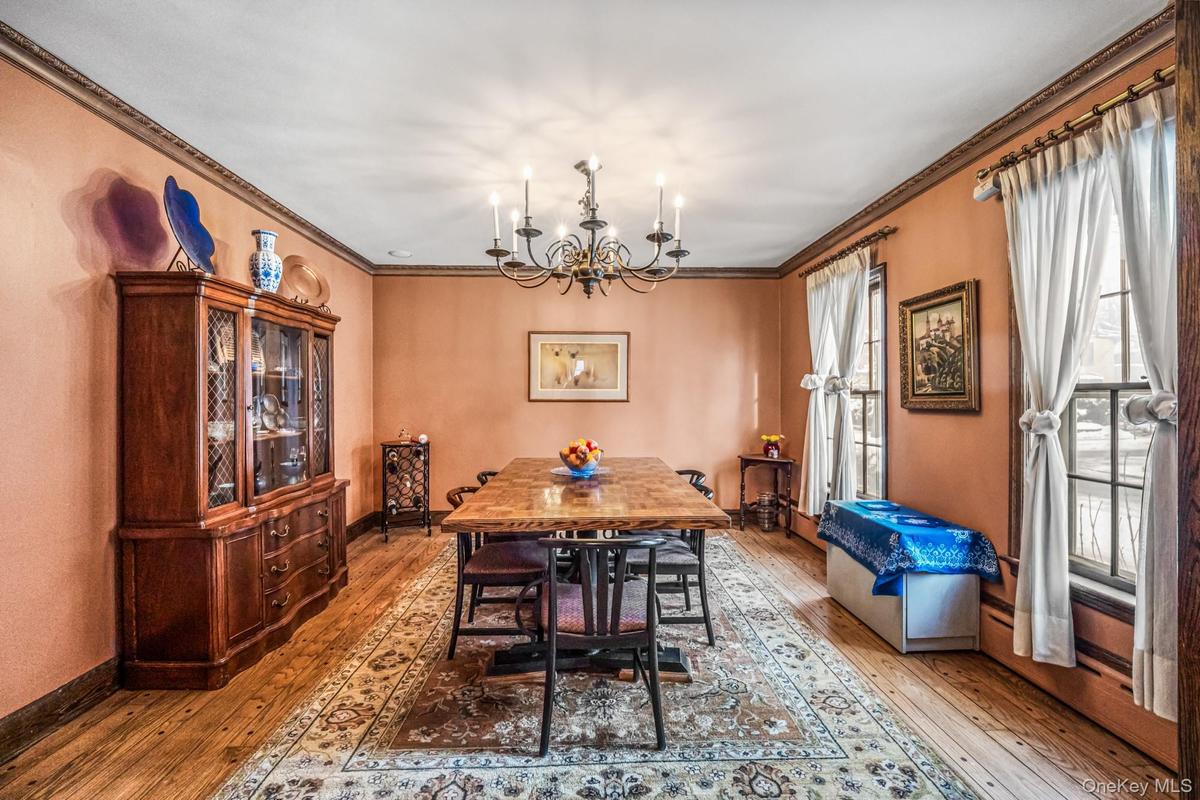 Dining area with hardwood / wood-style floors, a chandelier, and ornamental molding