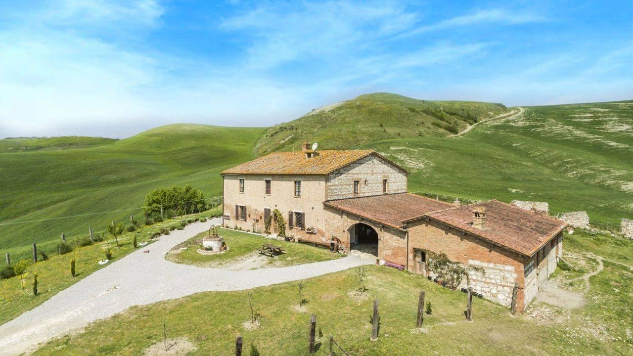 Property with restored farmhouse divided into 3 flats, annexes and 1.5 ha land for sale in the Crete Senesi, Tuscany.