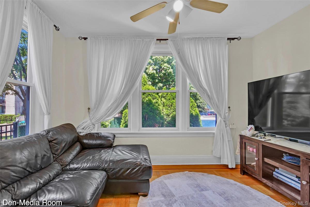 Bright living space featuring natural light from multiple windows and wood-finish flooring