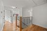 Corridor with an upstairs landing, light wood-style flooring, and recessed lighting