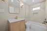 Bathroom featuring vanity, tile walls, and shower combination