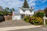 Front of house from street showing driveway garage and front yard plantings