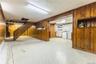 Finished basement with wood walls, light floors, washer and clothes dryer, and stairway