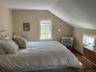 Bedroom featuring vaulted ceiling, dark wood-style floors, and a baseboard radiator