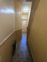 Hallway featuring stairway, radiator, and a wainscoted wall