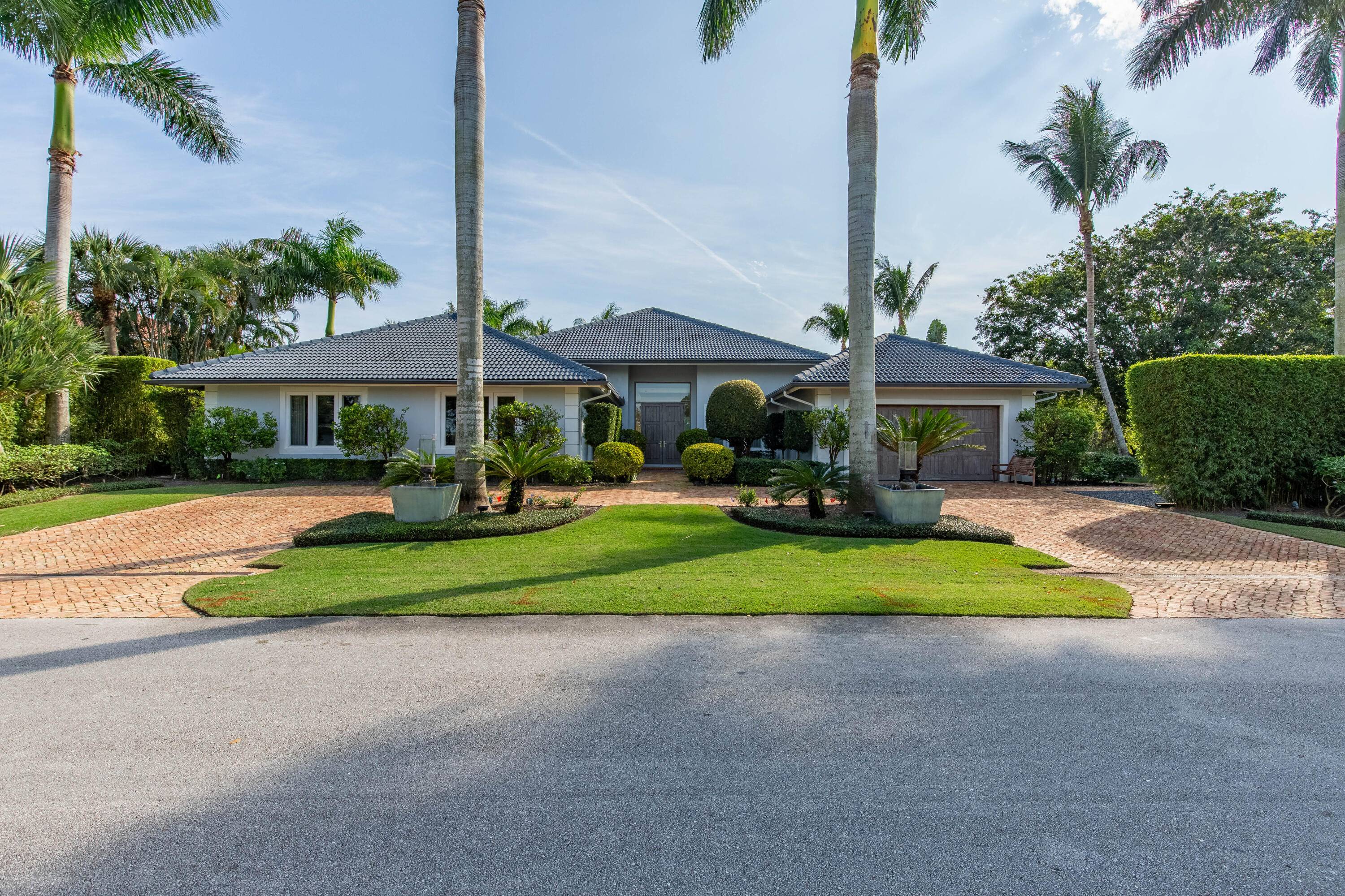 Nestled in the prestigious Golf Brook neighborhood of Palm Beach Polo and Country Club, this completely renovated 5 bedroom, 5.