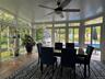 Sun room with extensive window panels, vaulted ceiling, Tiled flooring, a ceiling fan & A/C Unit