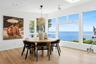 Dining space featuring light wood-style floors, a water view, a skylight, and recessed lighting