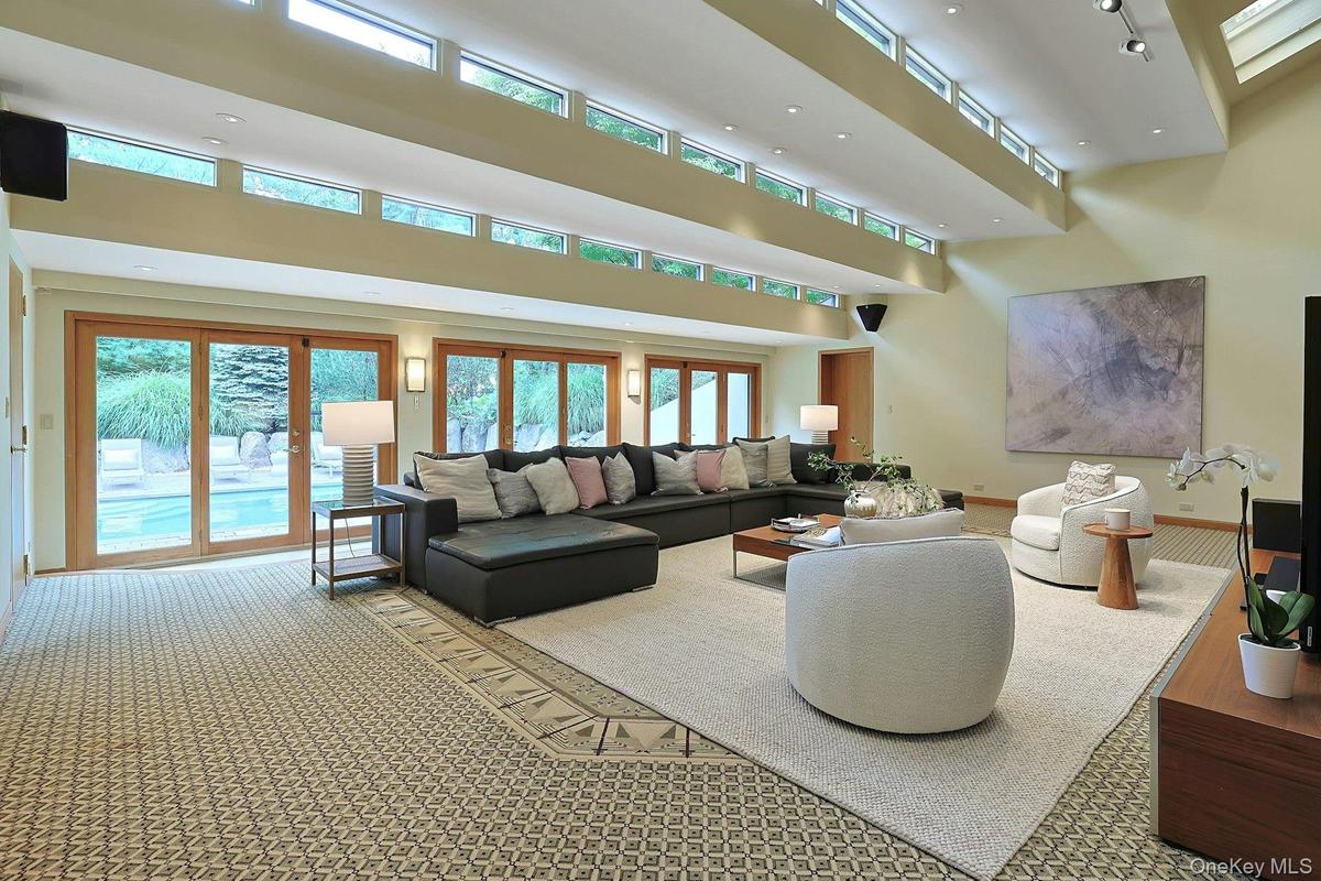 Designed for both grand entertaining and everyday comfort, this expansive gathering space is filled with natural light and serene views