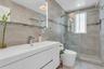 Contemporary bathroom featuring a floating white vanity with integrated sink, chrome faucet, and an illuminated mirror