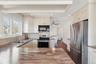 Kitchen featuring appliances with stainless steel finishes, dark hardwood / wood-style floors, sink, backsplash, and kitchen peninsula
