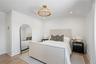 Bedroom featuring a decorative wall, light wood-style flooring, and recessed lighting