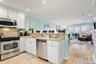 Kitchen featuring white cabinets, stainless steel appliances, a peninsula, a sink, and a breakfast bar area