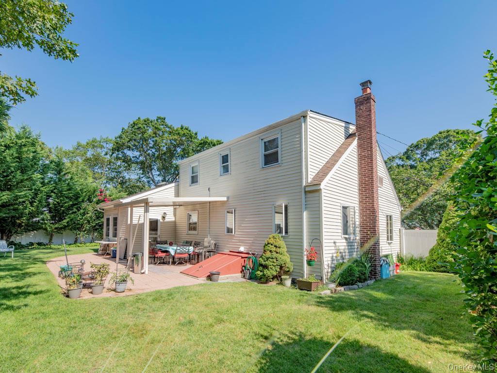 Rear view of house featuring a chimney and a patio