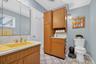 Half bathroom with tasteful backsplash, vanity, and light tile patterned floors