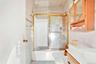 Full bath with tile walls, shower / bath combination with glass door, and vanity